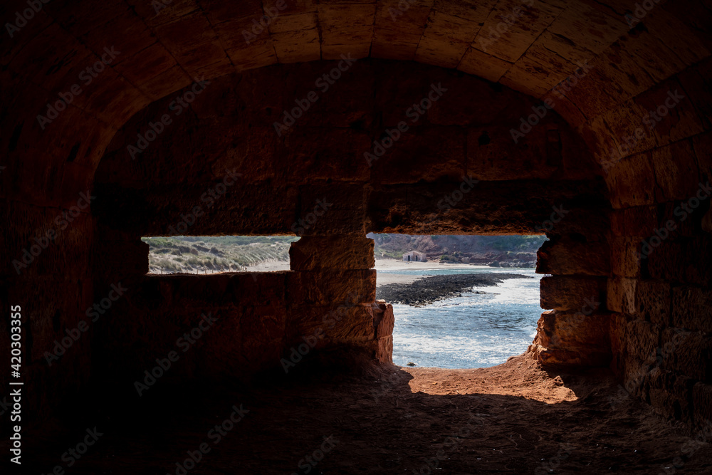 Interior of an abandoned bunkear near Algaiarens beach in a clear day with blue sky, located in the north of Minorca, in Balearic Islands, Spain.