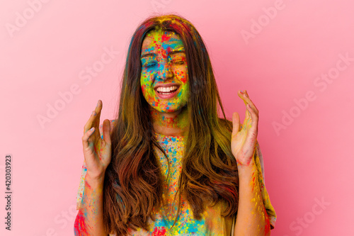Young Indian woman celebrating holy festival isolated on white background joyful laughing a lot. Happiness concept.