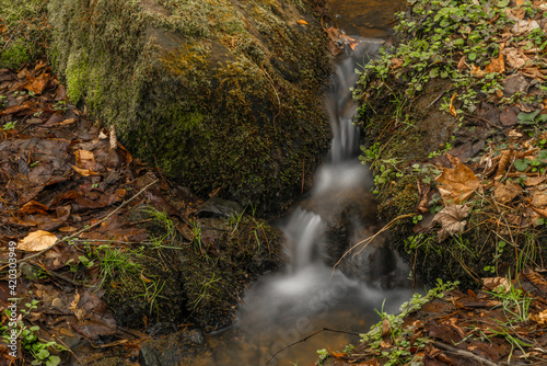 Small creek with waterfall near Vltava river in valley north from Hluboka town