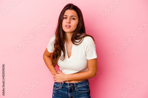 Young Indian woman isolated on pink background having a liver pain, stomach ache. © Asier