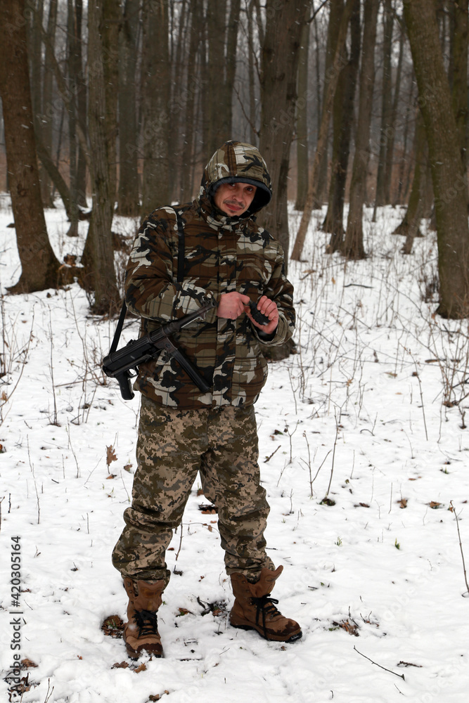 A soldier with hand grenade in the snowy forest