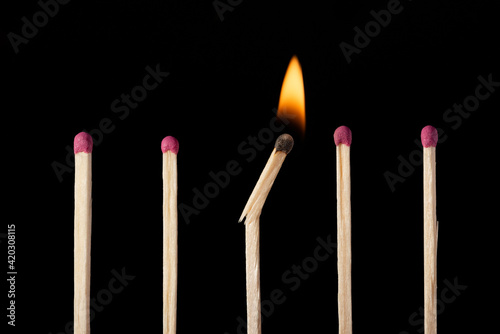 One broken burning match in line with other ordinary unignited matches. Concept of diversity, different