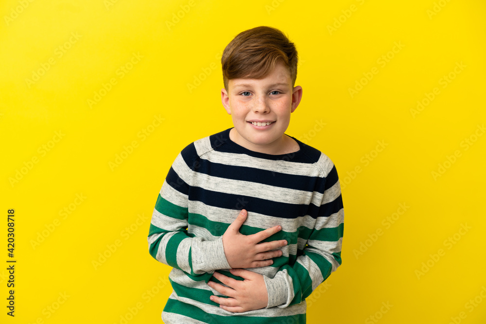 Little redhead boy isolated on yellow background smiling a lot Little redhead boy isolated on yellow background smiling a lot