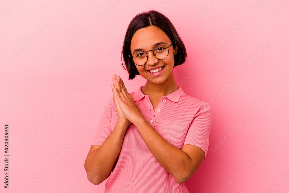 Young mixed race woman isolated on pink background feeling energetic and comfortable, rubbing hands confident.