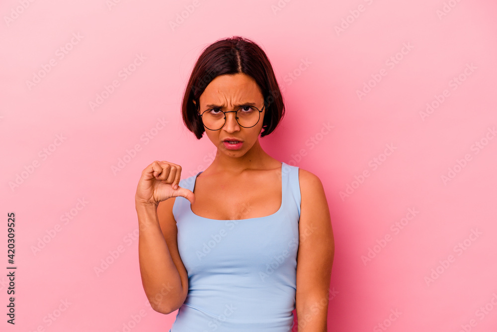 Young mixed race woman isolated on pink background showing thumb down, disappointment concept. Young mixed race woman isolated on pink background showing thumb down, disappointment concept.