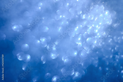 Abstract blurred blue background with glowing bokeh. Sunrays and air bubbles in deep sea