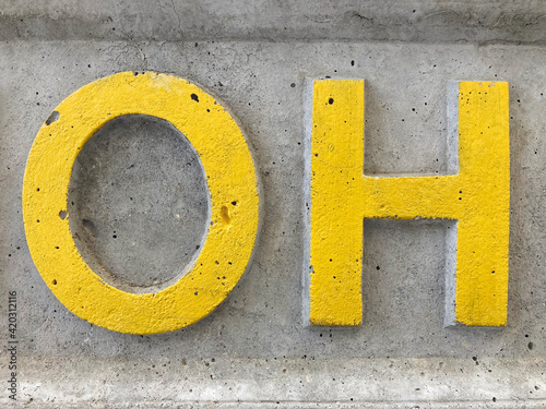sign on the street, Exclamation "oh", cracked grey asphalt with yellow letters o and h, no person