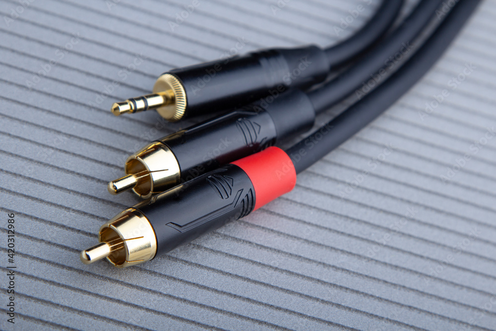 Hi-Fi RCA gold audio cable on grey background Hi-Fi RCA gold audio cable on grey background