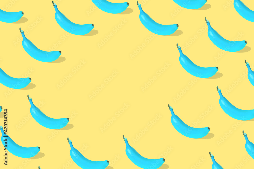 Trendy Summer pattern made with fresh banana fruit colored in blue on bright yellow background. Trendy Summer pattern made with fresh banana fruit colored in blue on bright yellow background.
