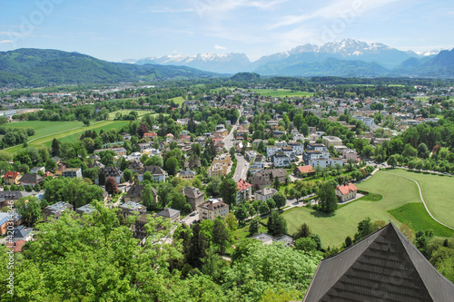 Austria, Salzburg, Europe. spring landscape of Salzburg at the bottom of the mountainous Alps, view from above. Urban landscape in a green valley among trees.