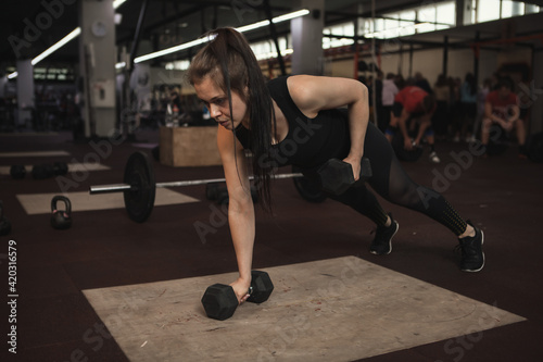 Athletic woman exercising with dumbbells  doing push ups