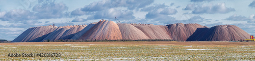 Extracting and mining potassium and magnesium salts. Large excavator machine and Huge mountains of waste ore in the extraction of potassium, Belarus, Soligorsk. Panoramic view