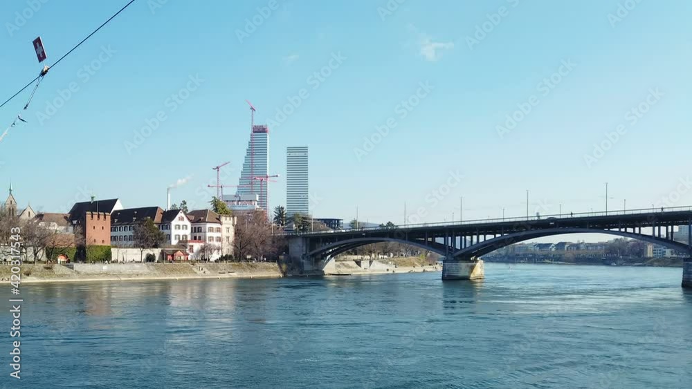 Basel city riverside skyline with traffic,constrution cranes and walking people,urban switzerland