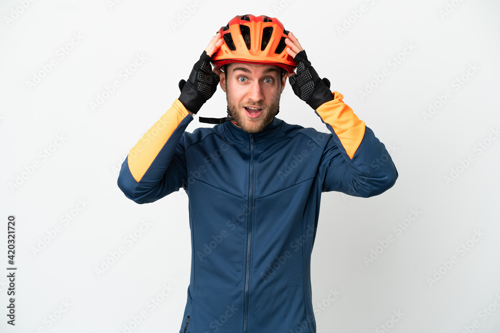 Young cyclist man isolated on white background with surprise expression