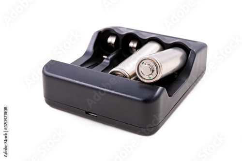 Black charger and silver batteries for energy storage. Accessories for powering household appliances.