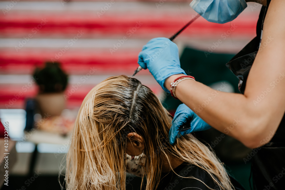 Fototapeta premium hairdresser coloring blonde balayage hair