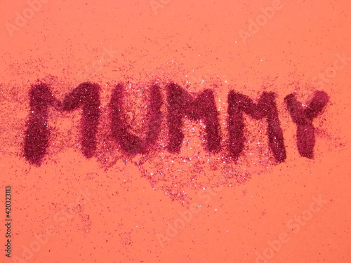 'Mummy' written in pink glitter on pink surface 
