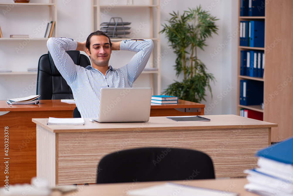 Young male employee sitting in the office Young male employee sitting in the office