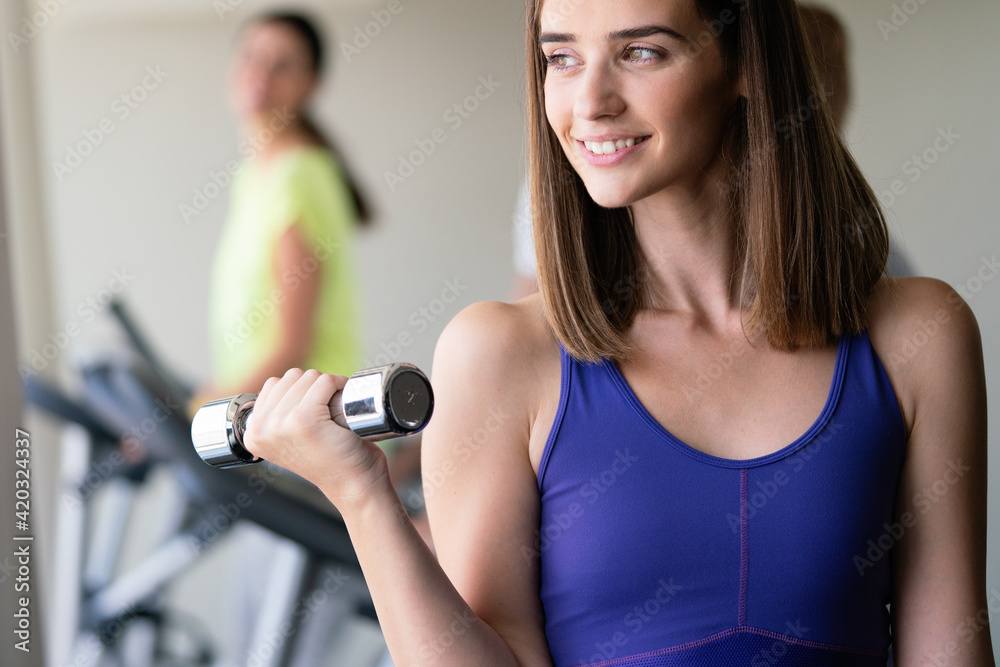 Portrait of a young happy fit woman with dumbbells Portrait of a young happy fit woman with dumbbells