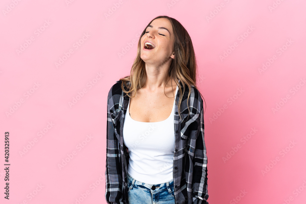 Young Romanian woman isolated on pink background laughing Young Romanian woman isolated on pink background laughing