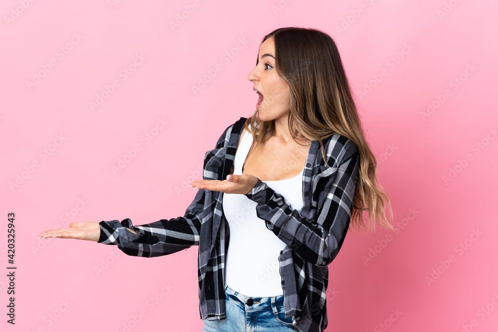 Young Romanian woman isolated on pink background with surprise expression while looking side Young Romanian woman isolated on pink background with surprise expression while looking side