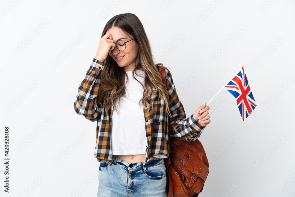 Young Romanian woman holding an United Kingdom flag isolated on white background laughing