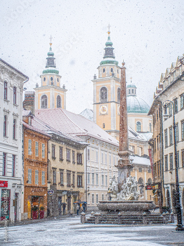 Ljubljana Town Square with Ljubljana cathedral and three bridges fountain during snowfall, Central Slovenia Region