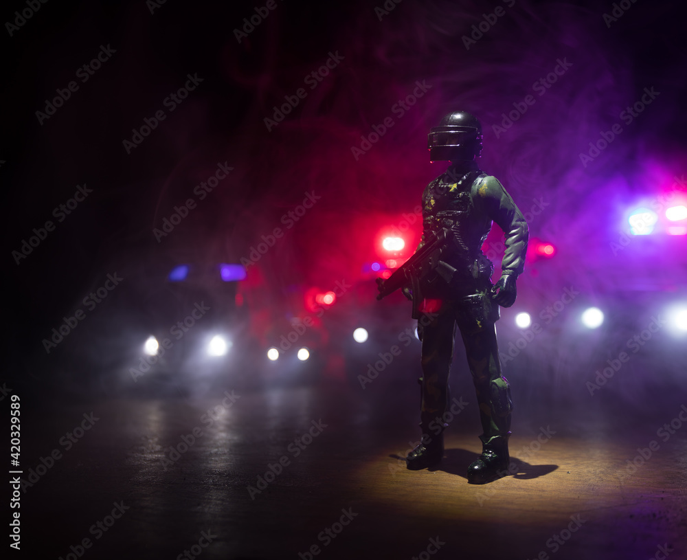 Fototapeta premium Anti-riot police give signal to be ready. Government power concept. Police in action. Smoke on a dark background with lights. Blue red flashing sirens. Dictatorship power