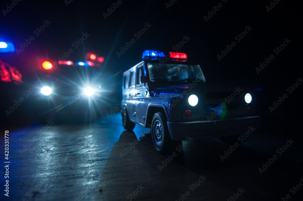 Police cars at night. Police car chasing a car at night with fog background. 911 Emergency response police car speeding to scene of crime. Police cars at night. Police car chasing a car at night with fog background. 911 Emergency response police car speeding to scene of crime.