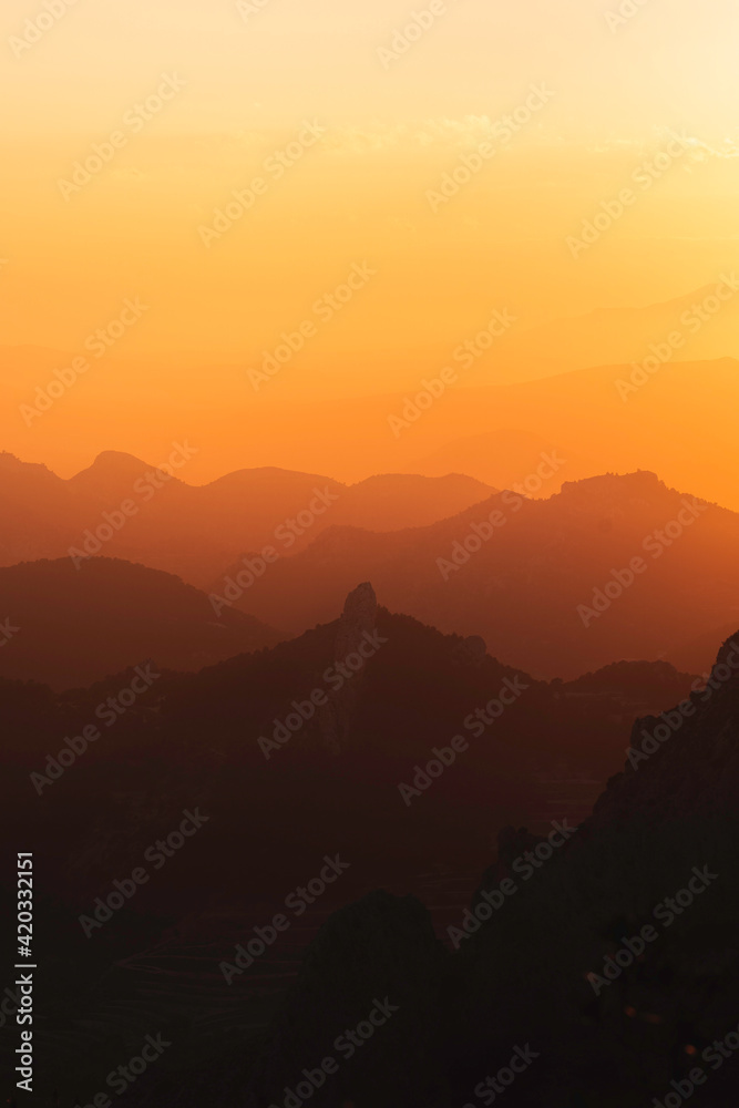 Stunning misty sunset over mountain silhouette horizon
