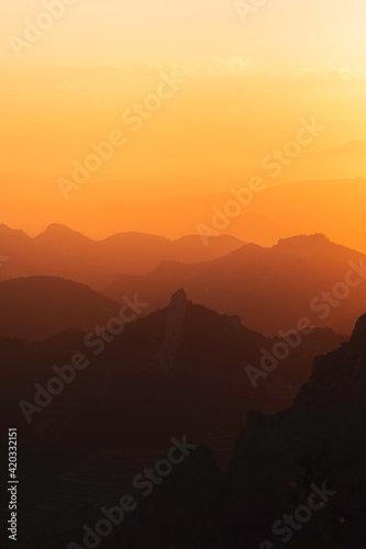 Stunning misty sunset over mountain silhouette horizon © Henko Studio