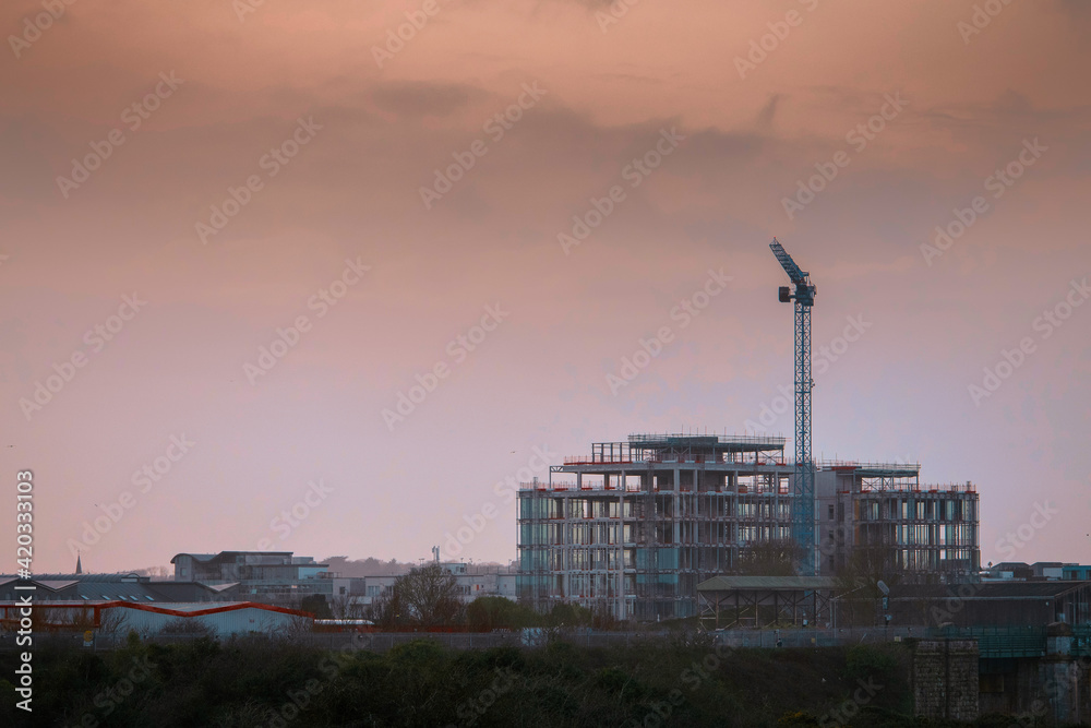 Construction site of Bonham quay with crane , cloudy sky. Galway city, Ireland, dusk time. Nobody.
