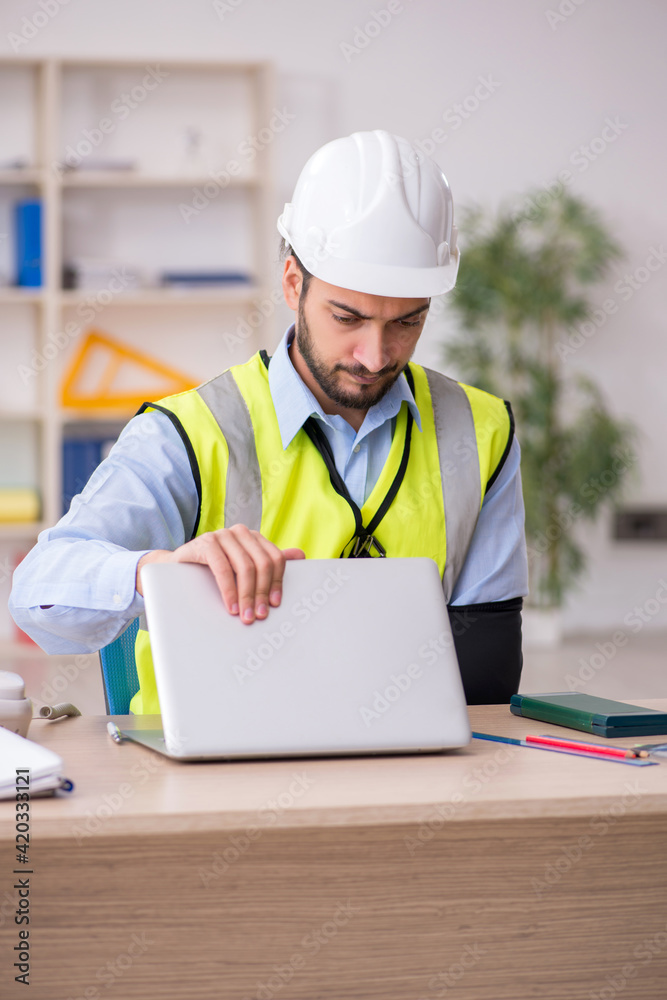 Young arm injured male architect working in the office Young arm injured male architect working in the office