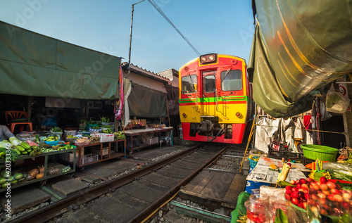 Umbrella Fresh Market on the Railroad Track, Mae Klong Train Station, Bangkok, Thailand on a Sunny Day © kaycco