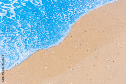 Blue sea water on light yellow beach sand