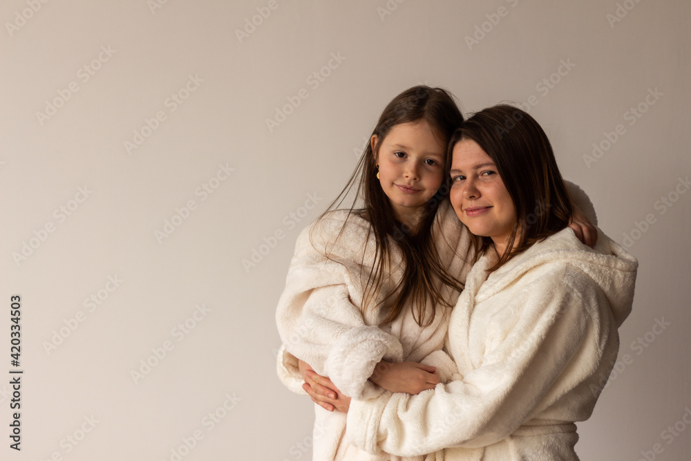 mother and daughter in bathrobes at home mother and daughter in bathrobes at home