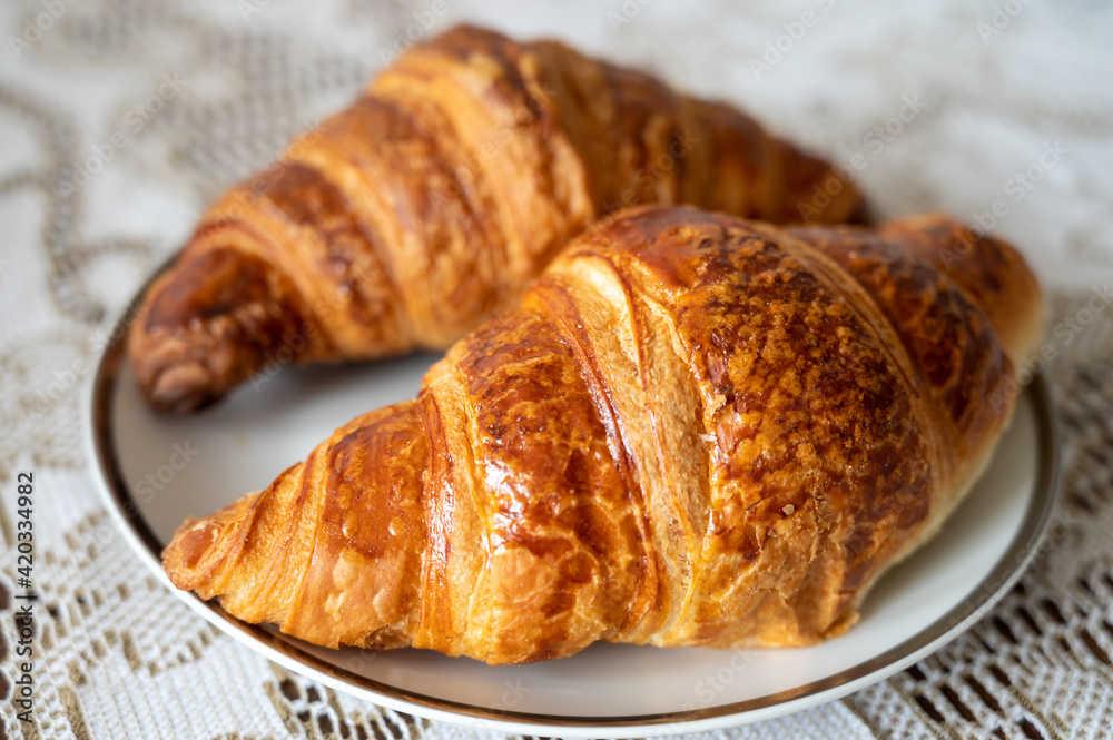 Two fresh baked puff croissants, traditional French breakfast