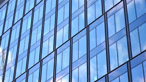 Modern office building with glass facade on a clear sky background. Transparent glass wall of office building.