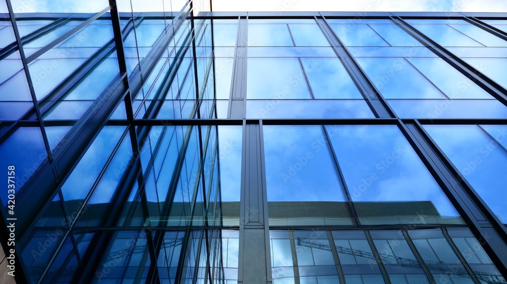 Modern office building with glass facade on a clear sky background. Transparent glass wall of office building.