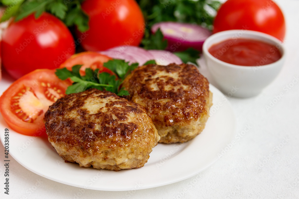 Homemade cutlets with sauce, on a white background.