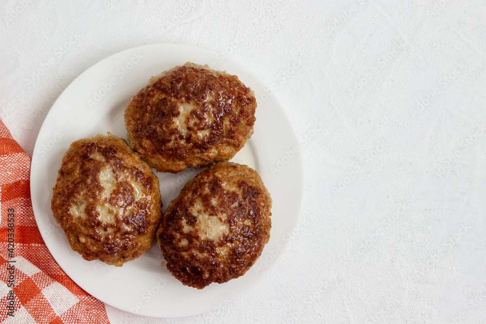 Homemade cutlets on a plate isolated on a white background. Homemade cutlets on a plate isolated on a white background.