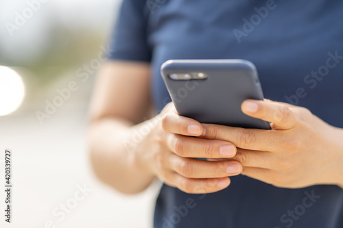 Asian woman using smartphone outdoors