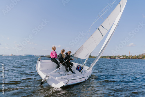 Dad and his two daughters went out on a yacht on the river to sail along the city, and teach the girls to conduct a sports yacht