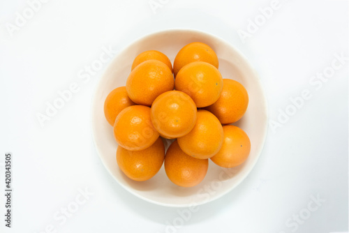 A saucer of kumquat isolated on white background, seasonal fruit