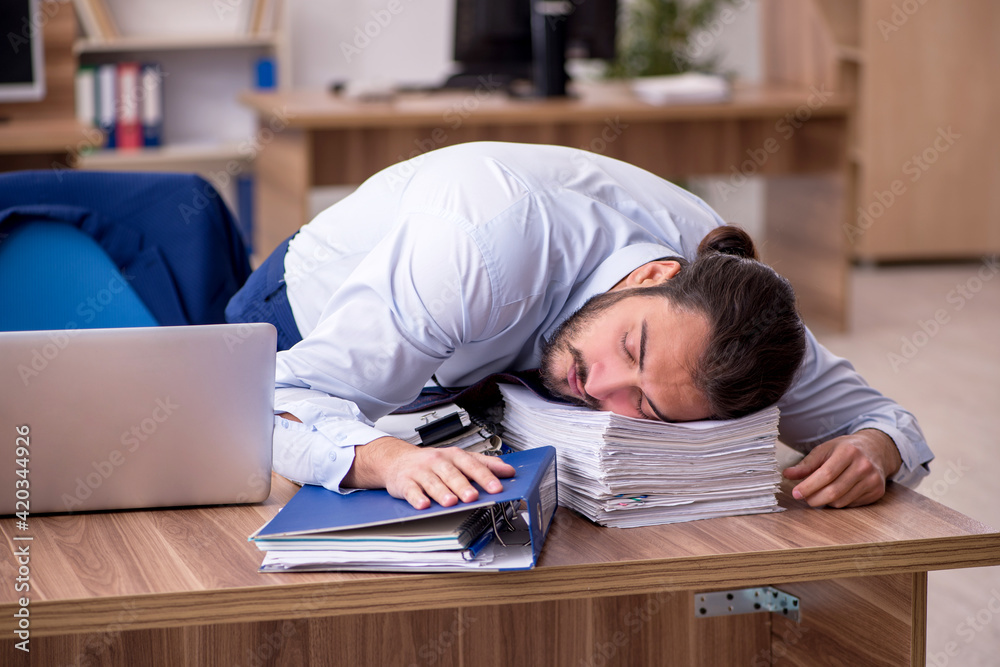 Young businessman employee unhappy with excessive work in the of Young businessman employee unhappy with excessive work in the of