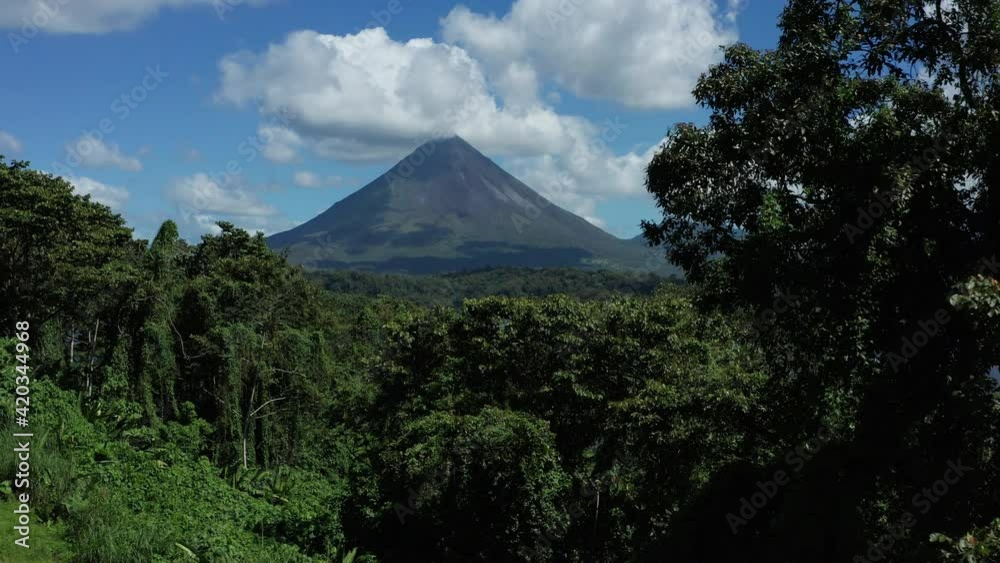 Drone flies forward over jungle canopy towards Lake Arenal and Arenal Volcano Drone flies forward over jungle canopy towards Lake Arenal and Arenal Volcano