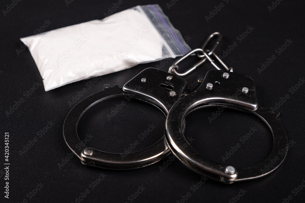 Fototapeta premium handcuffs and white powder closeup ,drug arrest