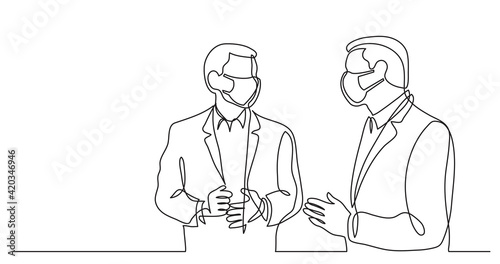 two standing businessmen wearing face masks talking discussing work problems