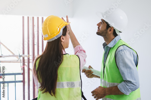 Fotografie Team of young caucasian, asian man and woman contractor, partner explain and inspecting the reconstructed construction and renovated to check defect of apartment, home,house at job site, workplace