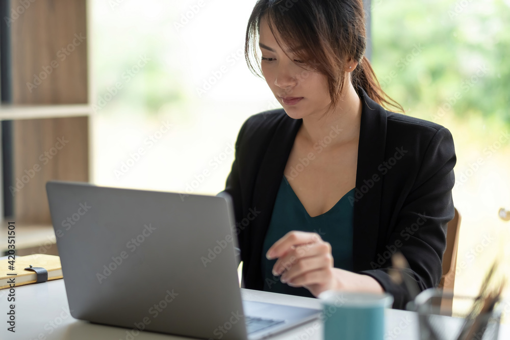 Asian businesswoman use a computer laptop and thinking idea for her business Asian businesswoman use a computer laptop and thinking idea for her business